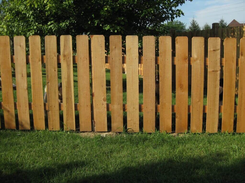Work with a trusted Carmel Fence Company in Bullseye Fence Design image shows wooden fence on grass
